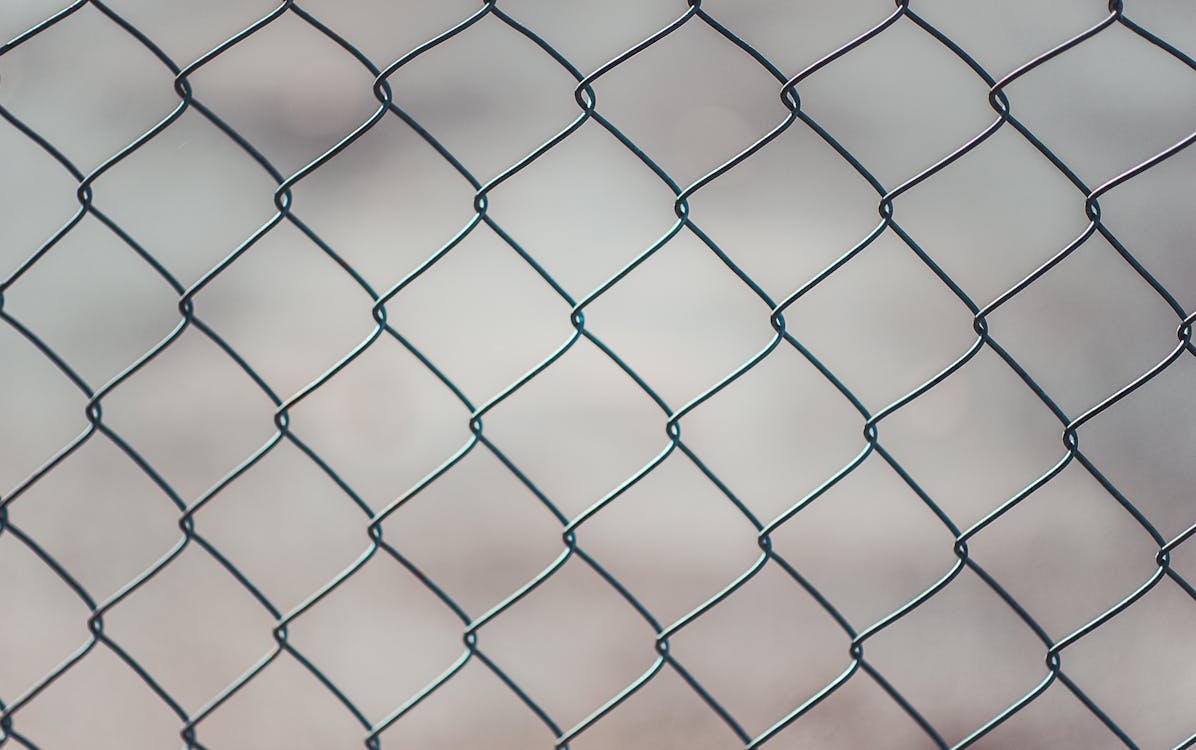 Galvanized chain link fence with metal posts along a property boundary