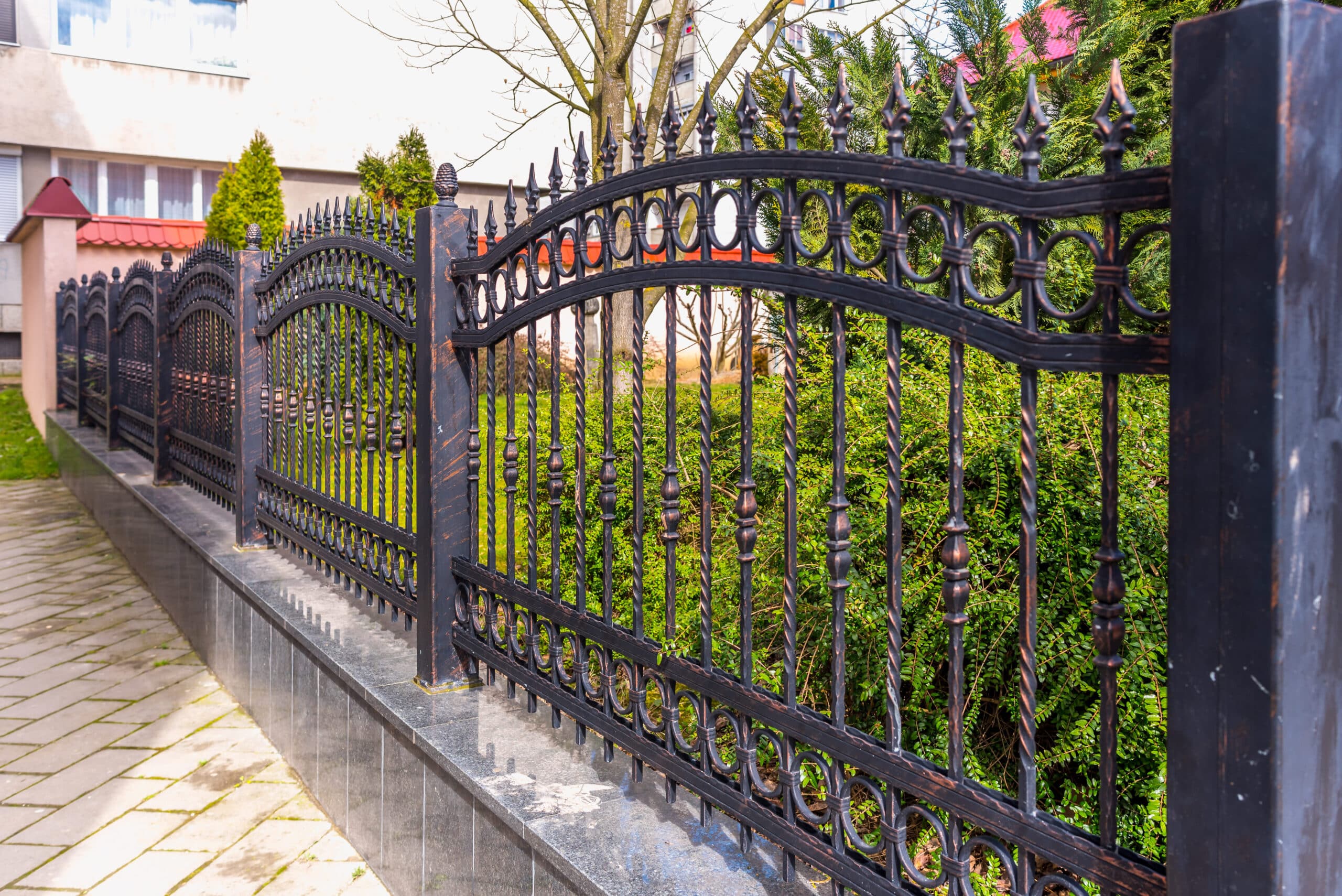 Black wrought iron fence with decorative pickets providing security and curb appeal